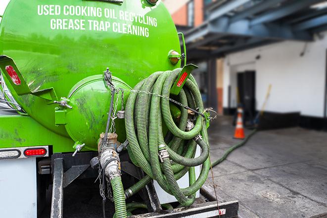 a grease trap being pumped by a sanitation technician in Fort Huachuca